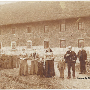 Bauernfamilie vor Vierkanthof in Oberösterreich