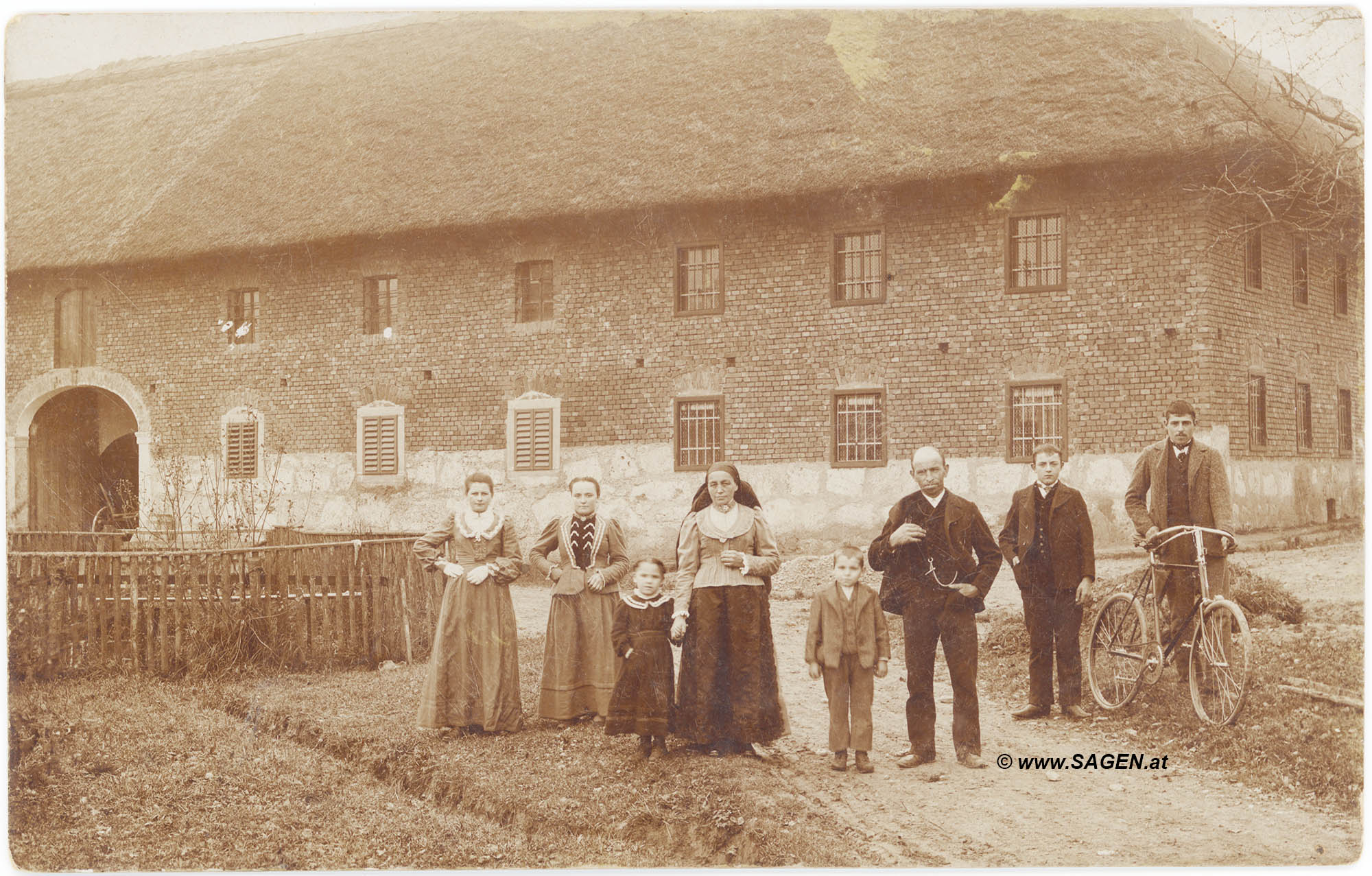 Bauernfamilie vor Vierkanthof in Oberösterreich