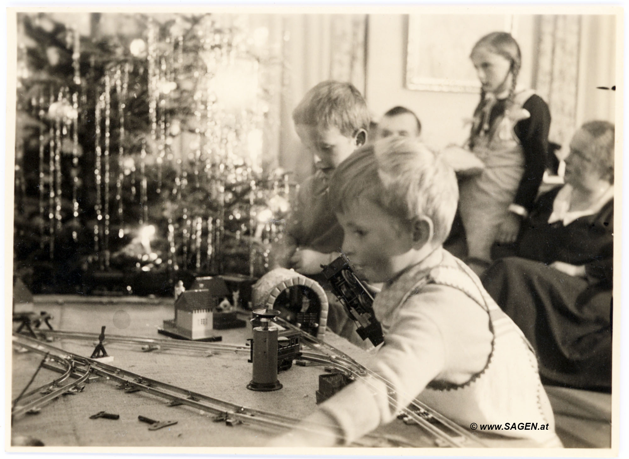 glückliche Kinder mit Modelleisenbahn unter dem Christbaum