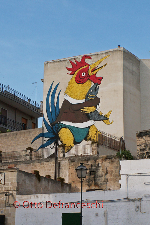 Hahn mit Fisch an einer Hausfassade in Grottaglie (Apulien/Italien)